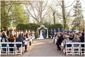 blonde bride and brunette groom in navy suit garden wedding