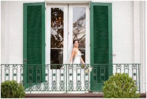 bridal portrait bride in white gown in front of window with green shutters