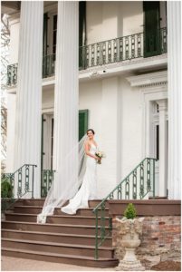 brunette bride white gown long veil on porch at riverwood mansion bridal session