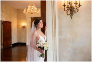 brunette bride white gown long veil on porch at riverwood mansion bridal session