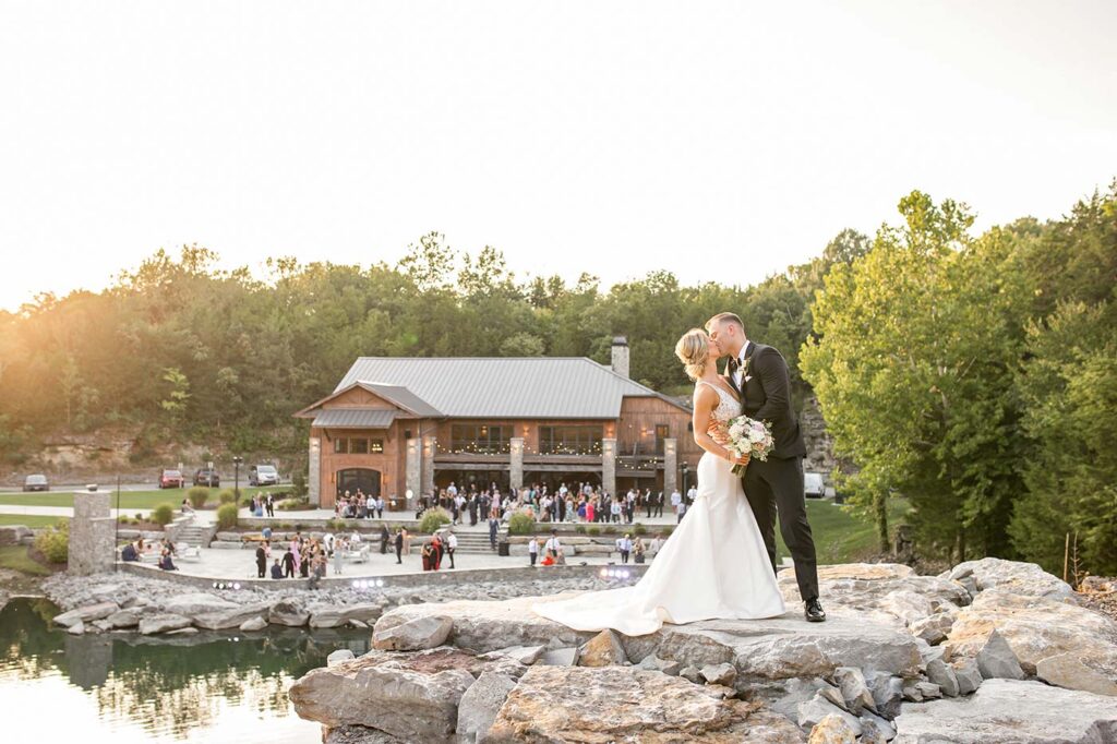 Newlyweds, Jill and Michael share a kiss at the top of the waterfall at the rock quarry wedding venue in Nashville called Gravestone Quarry.