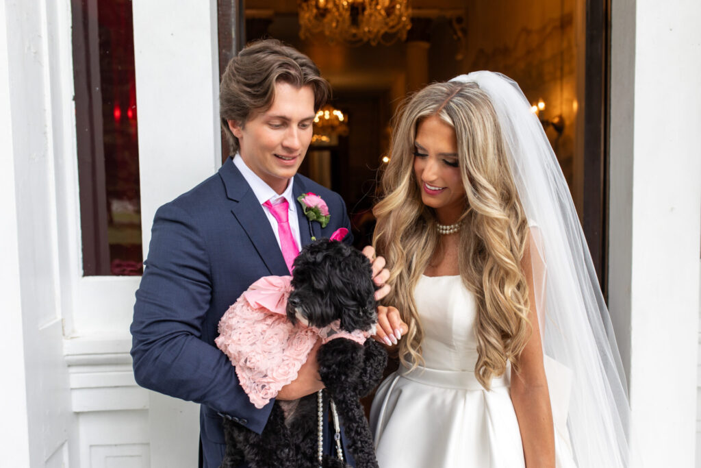 Bride and groom with their tiny black puppy at their wedding at Riverwood Mansion