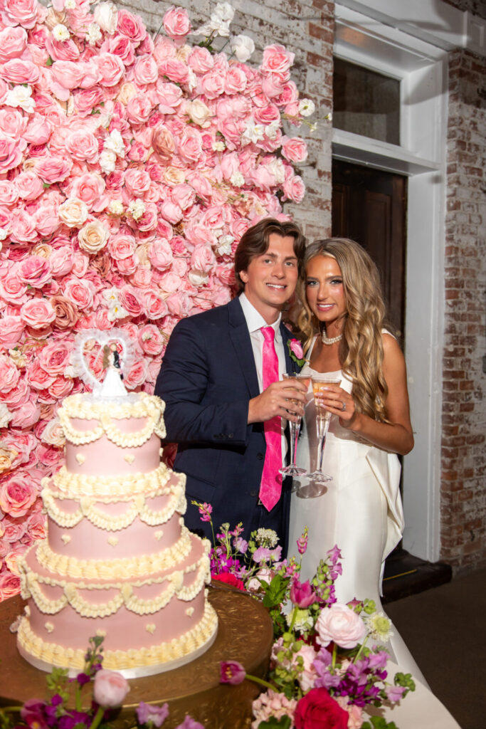 vintage inspired pink ruffled wedding cake and pink rose flower wall backdrop
